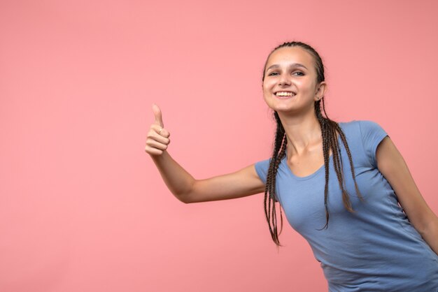 Front view of young female with smile on pink