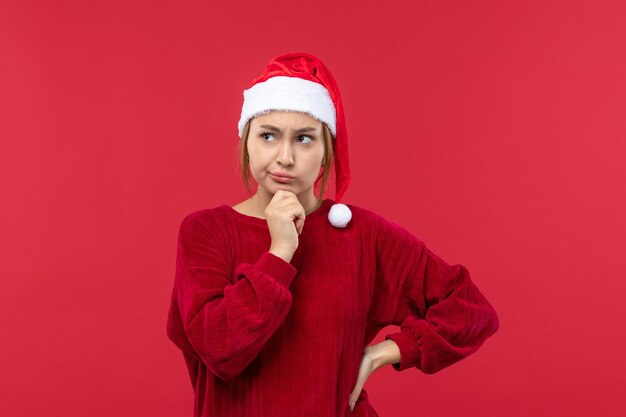 赤い机の休日の赤いクリスマスの思考表現を持つ正面図若い女性