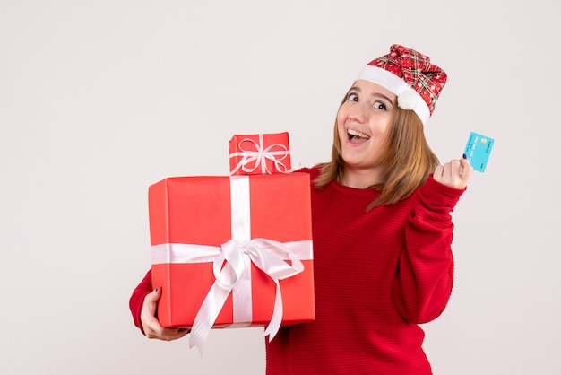 クリスマスプレゼントと銀行カードを持つ若い女性の正面図