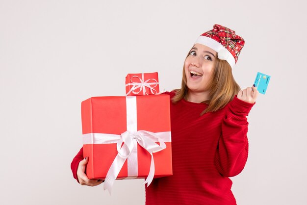 Вид спереди молодая женщина с рождественскими подарками и банковской картой