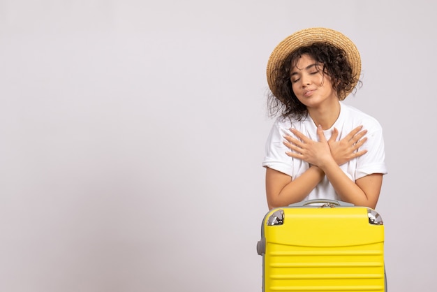 白い背景色の飛行船旅行の旅行の準備をしている黄色いバッグを持った正面の若い女性