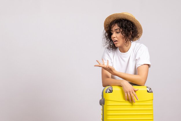 Front view young female with yellow bag preparing for trip on white background color flight voyage vacation sun rest tourist