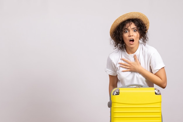 Front view young female with yellow bag preparing for trip on a white background flight rest voyage tourist vacation color plane sun