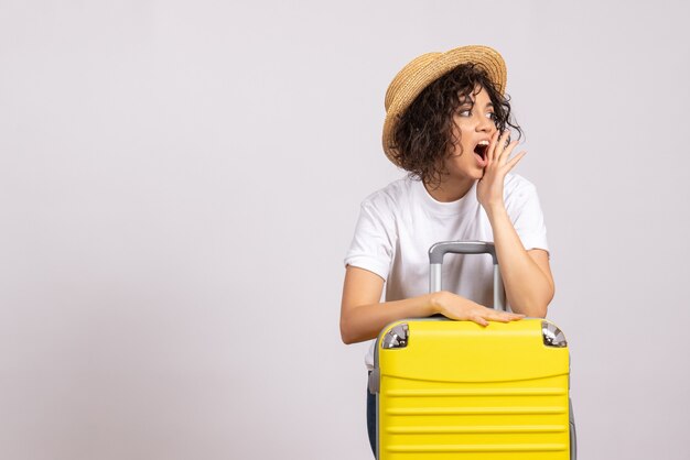 Front view young female with yellow bag preparing for trip on white background sun color voyage vacation plane rest flight