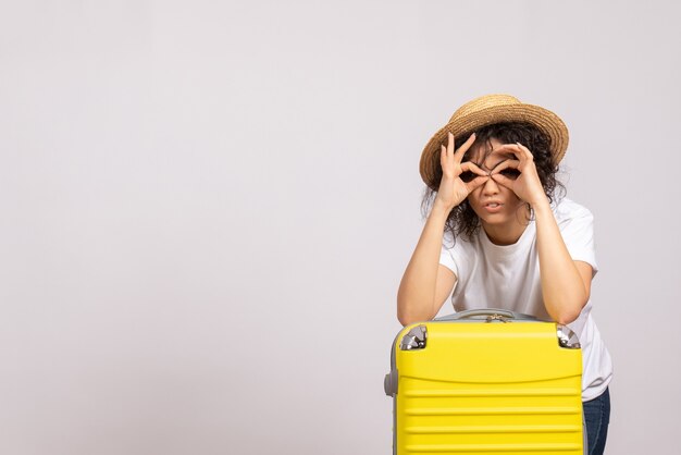 Front view young female with yellow bag preparing for trip on the white background sun color voyage vacation plane rest tourist flight