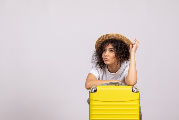 Front view young female with yellow bag preparing for trip on a white background vacation plane voyage color rest flight tourist