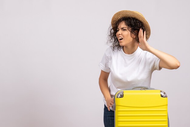 Front view young female with yellow bag preparing for trip on white background vacation plane voyage color rest tourist