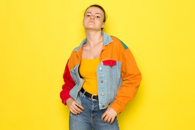 A front view young female in yellow shirt colorful jacket and blue jeans just boxing