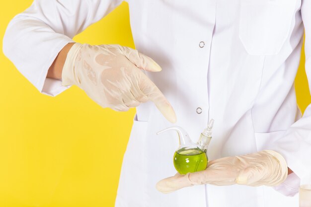 Front view of young feman chemist in white suit working with chemical solutions