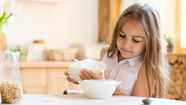 朝食にシリアルを食べる少女の正面図