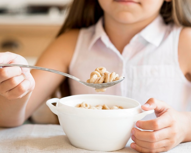 朝食にシリアルを食べる少女の正面図