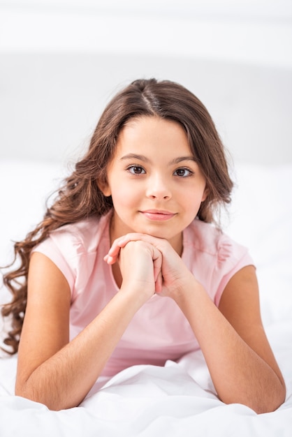 Front view young girl at home staying in bed