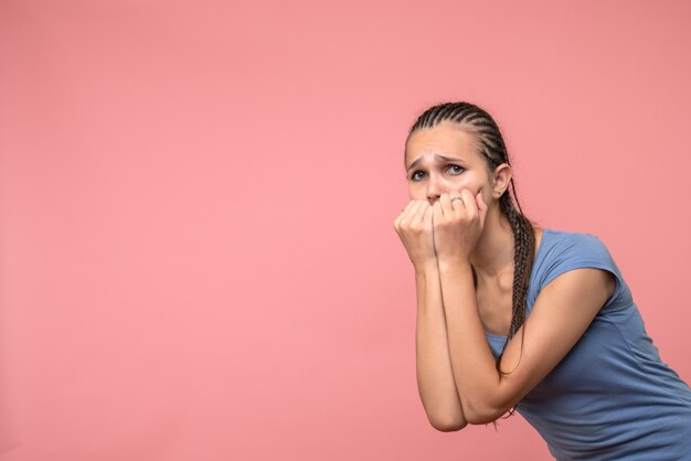 Front view of young girl nervous and scared on pink