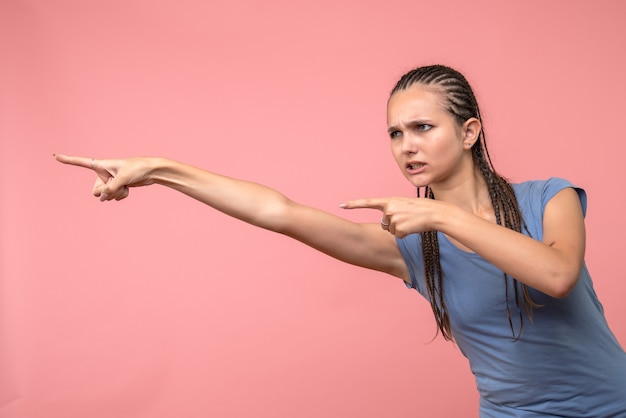 Front view of young girl pointing on pink