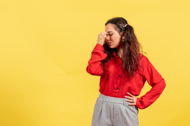 Front view young girl in red blouse with cute hair and hurt face on yellow background innocence child girl youth color kid