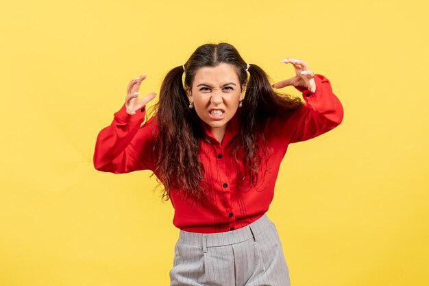 Free photo front view young girl in red blouse with frightening face on yellow background female feeling child kid girl youth emotion