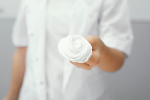 Front view of young girl scientist holding slime