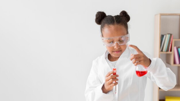 Front view of young girl scientist with potions