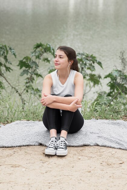 Front view young girl sitting outdoor