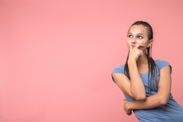 Front view of young girl thinking on pink