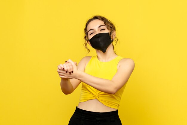 Front view of young girl with delighted face on yellow wall