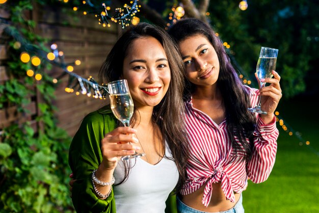 Front view young girls with champagne glasses