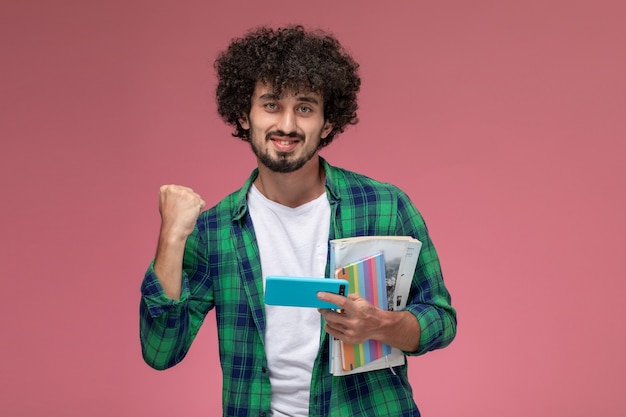 Front view young guy doing victory gesture on pink background