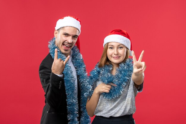 Front view young happy couple in new year mood on a red wall color christmas love