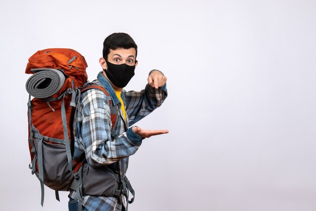 Front view young hiker with backpack and black mask standing on white background