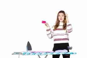 Foto gratuita giovane casalinga di vista frontale che tiene la carta di credito rosa su bianco