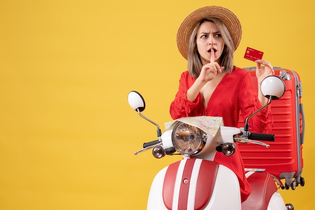 Front view young lady in confusion holding credit card near moped