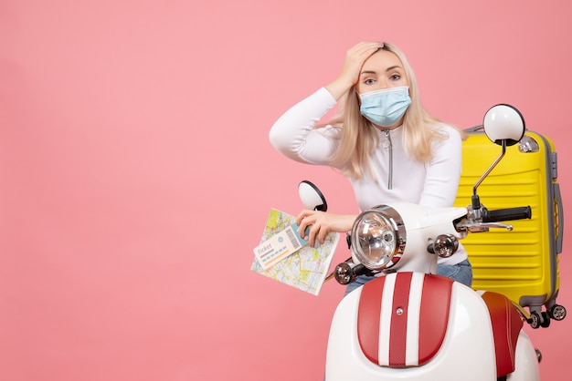 Free photo front view young lady on moped with yellow suitcase holding tickets and maps confusing