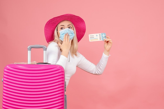 Front view young lady near suitcase holding plane ticket