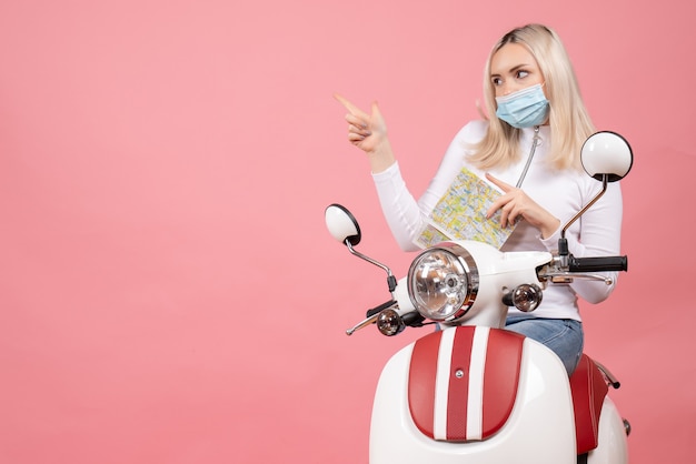 Free photo front view young lady pointing at left on moped