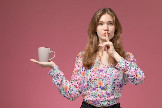 Foto gratuita giovane signora di vista frontale che posa gesto di silenzio con la tazza