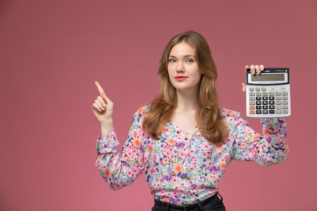Бесплатное фото Вид спереди молодая дама позирует со своим калькулятором