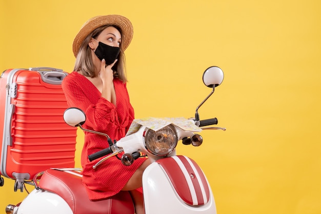 Front view young lady in red dress on moped thinking about something