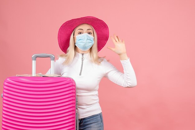 Front view young lady standing near suitcase waving map