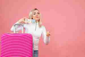 Free photo front view young lady standing behind pink suitcase holding plane ticket