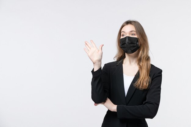 Front view of young lady in suit wearing surgical mask and showing five on white