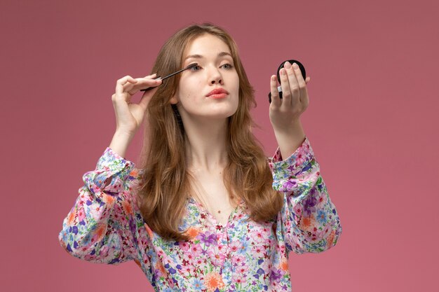 Front view young lady using her make-up accessory