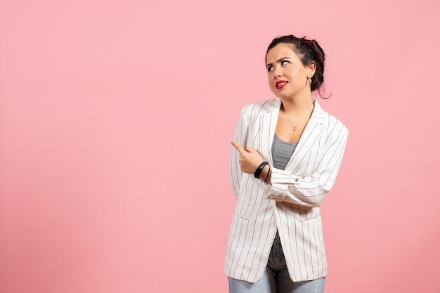 Front view young lady in white jacket with curious face on pink background fashion woman emotion color feeling lady