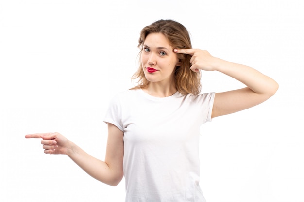 A front view young lady in white shirt and black modern jeans posing on the white