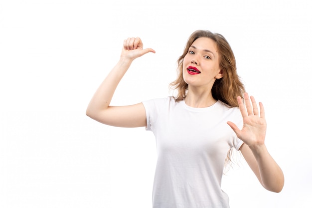 A front view young lady in white shirt and black modern jeans posing on the white