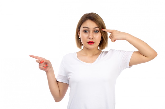 A front view young lady in white shirt posing thinking on the white