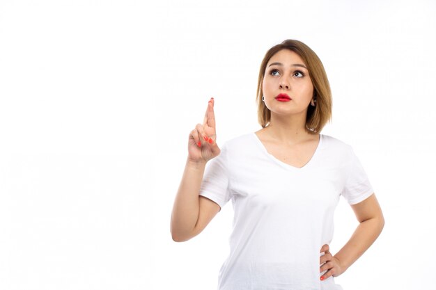 A front view young lady in white shirt posing thinking on the white