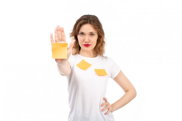 A front view young lady in white shirt with orange notes and black modern jeans posing on the white