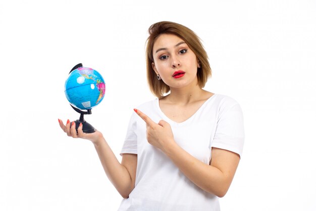 A front view young lady in white t-shirt holding little globe on the white