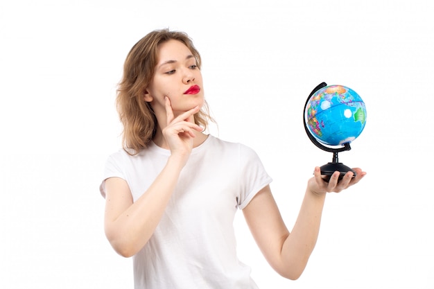 A front view young lady in white t-shirt holding little round globe on the white