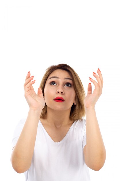 A front view young lady in white t-shirt posing looking into the skies on the white